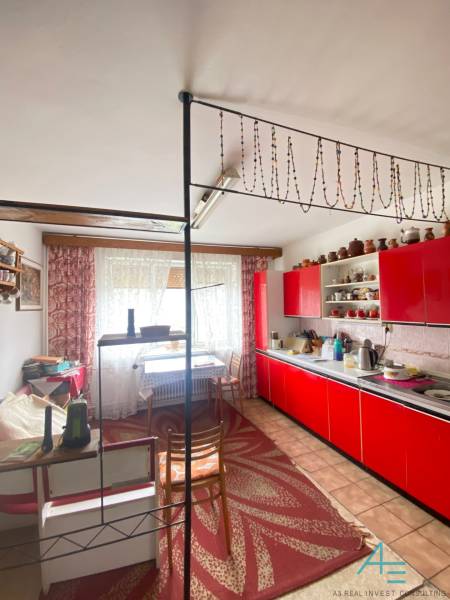 RD so záhradou, pivnicou garážou na Myjave.  - Červená kuchynská linka v rodinnom dome s dekoratívnym závesom a bodkovaným kobercom.