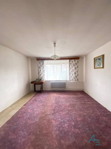 RD so záhradou, pivnicou garážou na Myjave.  - Izba v rodinnom dome s fialovým kobercom, kvetinovými závesmi a lustrom.