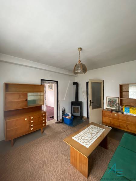 RD so záhradou, pivnicou garážou na Myjave.  - Obývacia izba v rodinnom dome s dreveným nábytkom a kachľami na kúrenie.