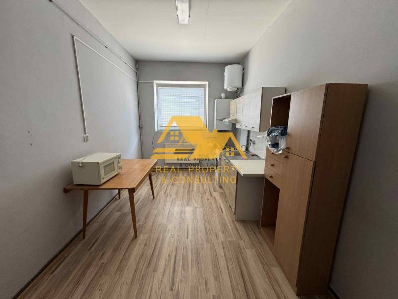 Prenajmem garsónku v Nesvadoch - Jednoduché zariadenie garsónky s kuchynským kútom a podlahou s dreveným dekorom.