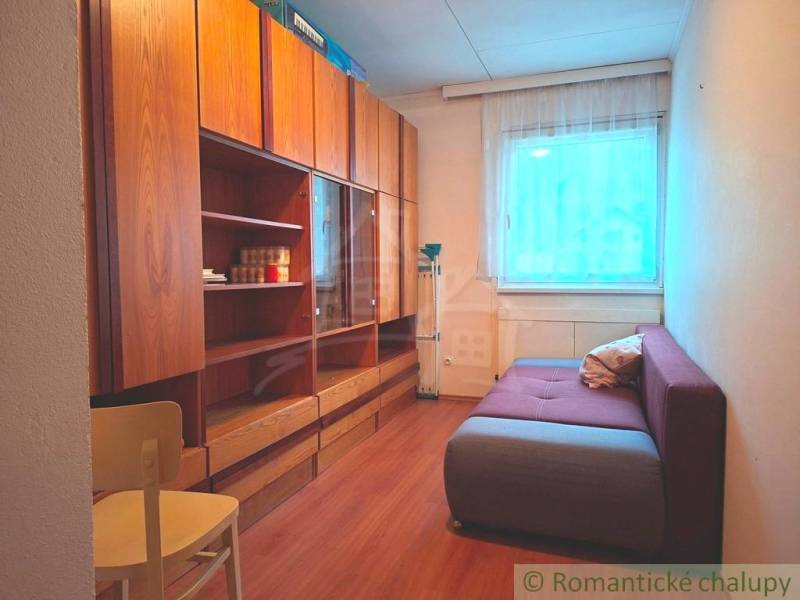 Veľkorysý 10-árový pozemok, slnečná nehnuteľnosť, priestranné bývanie  - Izba s pohovkou, skriňami a podlahou s dreveným dekorom v rodinnom dome.