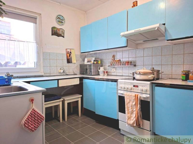 Veľkorysý 10-árový pozemok, slnečná nehnuteľnosť, priestranné bývanie  - Kuchyňa v rodinnom dome s modrými skrinkami a kachličkovou stenou.