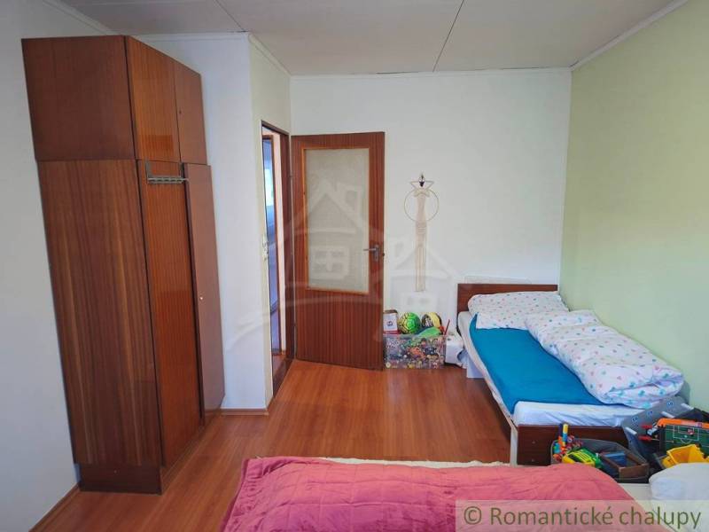 Veľkorysý 10-árový pozemok, slnečná nehnuteľnosť, priestranné bývanie  - Detská izba v rodinnom dome s podlahou s dreveným dekorom a hračkami.