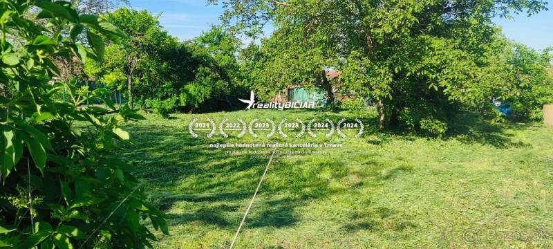 Slnečný stavebný pozemok v tichom srdci Dolného Dubového - Trávnaté pozemky pre bývanie v Dolnom Dubovom s bohatou zeleňou a stromami.
