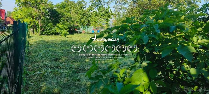 Slnečný stavebný pozemok v tichom srdci Dolného Dubového - Pozemky na bývanie v Dolnom Dubovom, ulica Dolné Dubové. Zavlažovaná, oplotená záhrada so stromami.