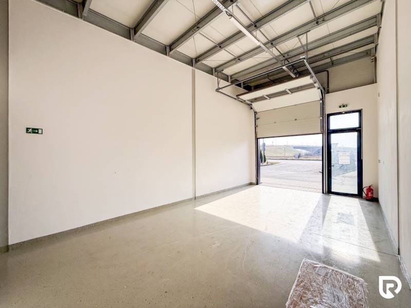 Na prenájom obchodný priestor + sklad, 120m2, FIRMBOX, Trenčín - Obchodné priestory s veľkou garážovou bránou a sivou podlahou s osvetlením.
