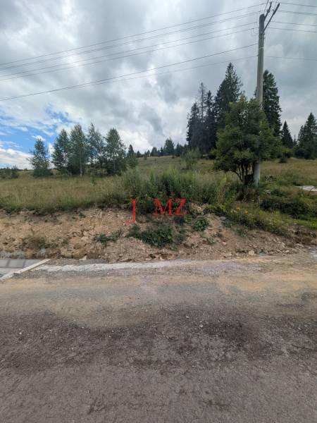Stavebný pozemok kúsok od lyžiarskych vlekov Čierny Balog - Bexeľ - Pozemky na bývanie v Čiernom Balogu, cesta, stĺp elektrického vedenia a zeleň.