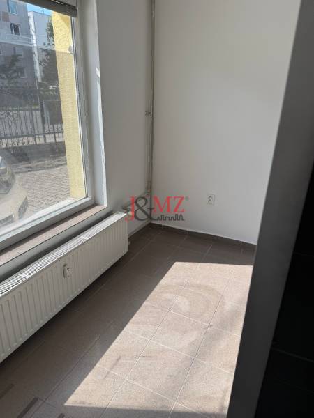 Obchodný priestor, kancelária Sarartovská ul.  - Obchodné priestory s veľkým oknom a radiátorom, dlažba na podlahe.