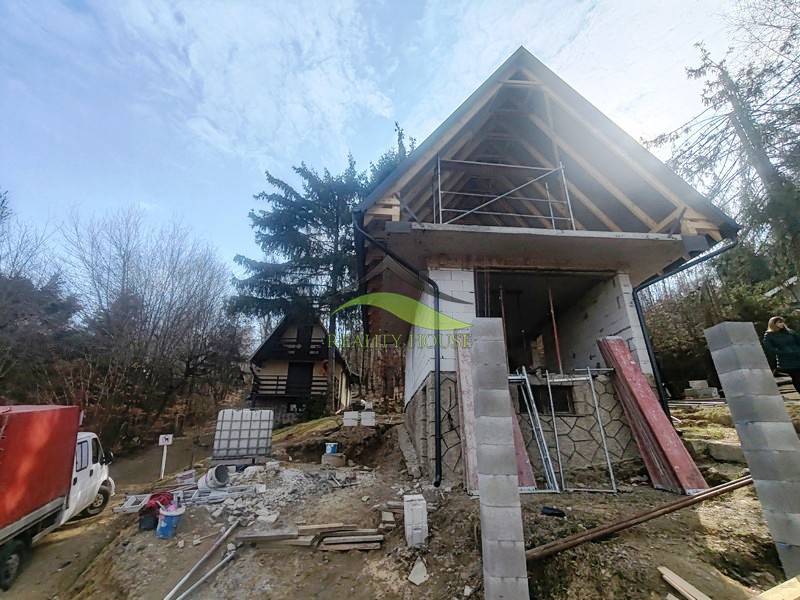 RO Domaša Zajačia Debra - Chata pri vode! - Stavba chaty na Zajačej debre v Holčíkovciach obklopená stromami a stavebným materiálom.