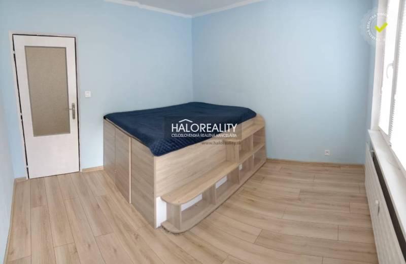Prenájom, trojizbový byt Podbrezová, Štiavnička - Spálňa s vyvýšeným lôžkom a podlahou s dreveným dekorom v 3-izbovom byte.