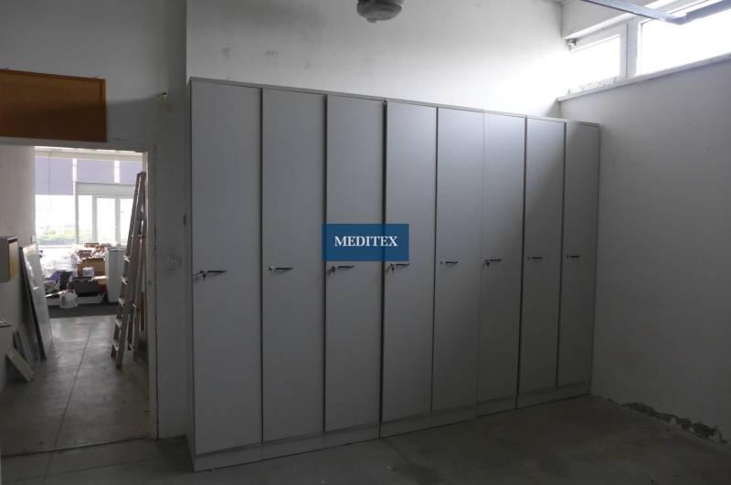 Obchodný priestor na prenájom pri ceste o ploche  372 m2  - Skrine v obchodných priestoroch s kovovou podlahou a bielymi stenami.