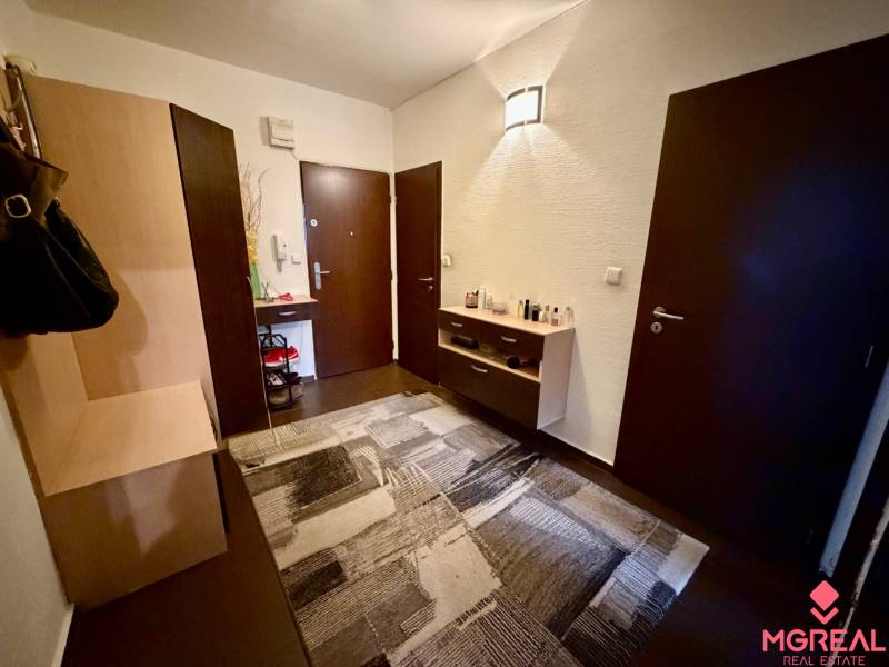 3 izbový byt  Topoľčany blízko centra - Predsieň s tmavými dverami, komodou, a podlahou s dreveným dekorom v 3-izbovom byte.