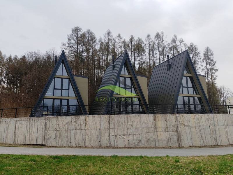 Luxusná Apartmánová chata Domaša Eva: Airbnb Hit! - Chaty na ulici Evy v Holčíkovciach s trojuholníkovou strechou obkolesené prírodou a lesom.