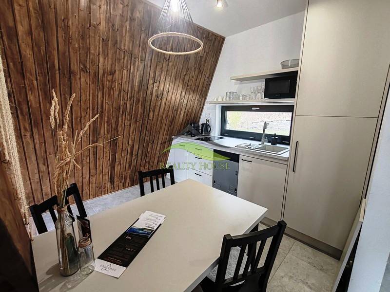 Luxusná Apartmánová chata Domaša Eva: Airbnb Hit! - Kuchyňa v Chate s podlahou s dreveným dekorom, drevenými stenami a moderným vybavením.