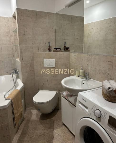 - PRENÁJOM - 2 IZBOVÝ BYT - DOLNÁ UL. - STARÉ MESTO - Kúpeľňa v 2-izbovom byte s vaňou, práčkou a jemnými béžovými obkladmi.