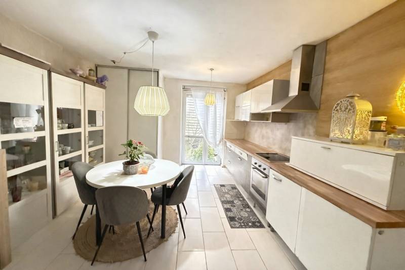 Rodinný dom vTopoľčanoch blízko centra REZERVOVANÉ - Kuchyňa v rodinnom dome s jedálenským stolom, bielou linkou a vstavanou rúrou.