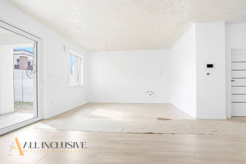 Na predaj 3-izb. byt so záhradou, Dunajská Streda - Priestranná izba s podlahou s dreveným dekorom a veľkými oknami v 3-izbovom byte.