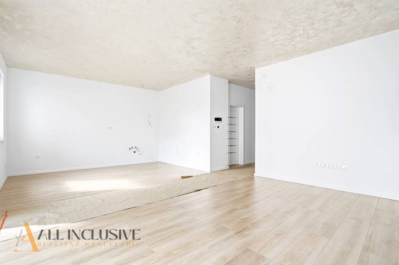 Na predaj 3-izb. byt so záhradou, Dunajská Streda - Priestranná miestnosť s bielymi stenami a podlahou s dreveným dekorom v 3-izbovom byte.