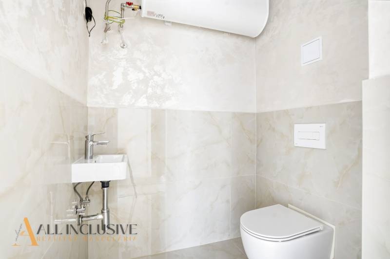 Na predaj 3-izb. byt so záhradou, Dunajská Streda - Kúpeľňa s toaletou a umývadlom v 3-izbovom byte, svetlý obklad, nádrž na vodu.