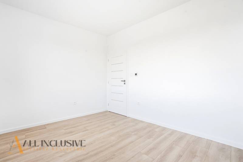 Na predaj 3-izb. byt so záhradou, Dunajská Streda - Prázdna izba s bielymi stenami a podlahou s dreveným dekorom v 3-izbovom byte.