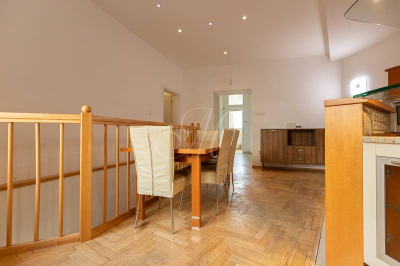 Priestranný 4-izbový byt s predzáhradkou, Staré Mesto - Jedálenský kút v 4-izbovom byte s podlahou s dreveným dekorom a jedálenským stolom.