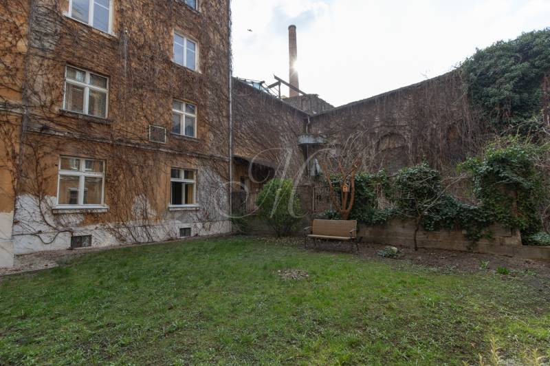 Priestranný 4-izbový byt s predzáhradkou, Staré Mesto - Dvor obytného domu na Medenej ulici v Bratislave - Staré Mesto s lavičkou a zeleňou.