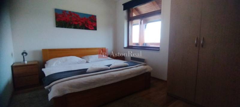 Predaj !Elegantný byt s wellness prvkami pri Jasnej - Spálňa s manželskou posteľou, obrazom kvetov a skriňou v 2-izbovom byte.