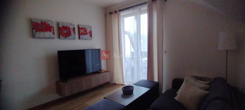 Predaj !Elegantný byt s wellness prvkami pri Jasnej - Obývacia izba s podlahou s dreveným dekorom, televíziou a gaučom, 2-izbový byt.