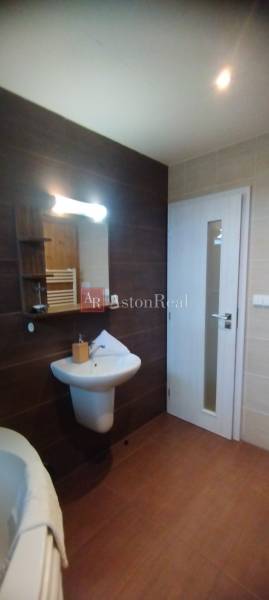 Predaj !Elegantný byt s wellness prvkami pri Jasnej - Kúpeľňa v 2-izbovom byte s umývadlom, zrkadlom a svetlými obkladmi.