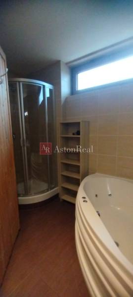 Predaj !Elegantný byt s wellness prvkami pri Jasnej - Kúpeľňa so sprchovacím kútom, rohovou vaňou a podlahou s dreveným dekorom v 2-izbovom byte.