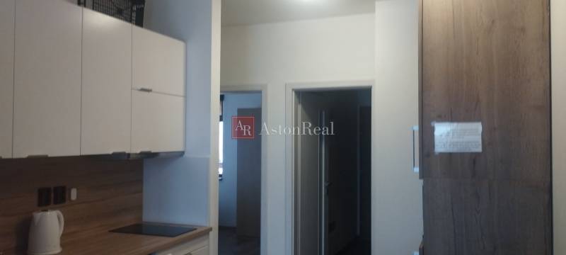 Predaj !Elegantný byt s wellness prvkami pri Jasnej - Kuchyňa s bielymi skrinkami a drevodekorom v 2-izbovom byte.