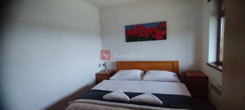 Predaj !Elegantný byt s wellness prvkami pri Jasnej - Spálňa s manželskou posteľou a drevenými nočnými stolíkmi v 2-izbovom byte.