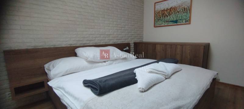 Predaj !Elegantný byt s wellness prvkami pri Jasnej - Spálňa s dreveným nábytkom a obrazom, podlaha s dreveným dekorom, 2-izbový byt.