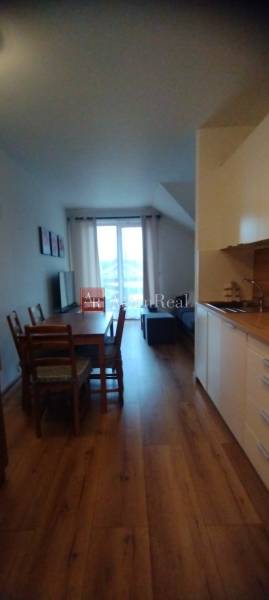 Predaj !Elegantný byt s wellness prvkami pri Jasnej - Kuchynský kút s jedálenským stolom a podlahou s dreveným dekorom v 2-izbovom byte.