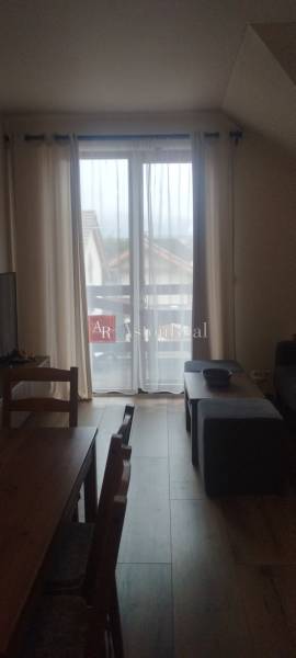 Predaj !Elegantný byt s wellness prvkami pri Jasnej - Obývačka v 2-izbovom byte s podlahou s dreveným dekorom a francúzskym oknom.