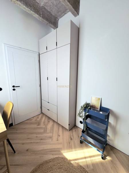 - PRENÁJOM - 3 IZBOVÝ BYT - WILSONOVA UL. - STARÉ MESTO - Štýlový kútik v 3-izbovom byte s podlahou s dreveným dekorom a úložným regálom.