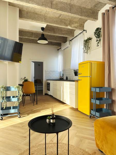 - PRENÁJOM - 3 IZBOVÝ BYT - WILSONOVA UL. - STARÉ MESTO - Interiér 3-izbového bytu s podlahou s dreveným dekorom, žltou chladničkou a bielou kuchynskou linkou.