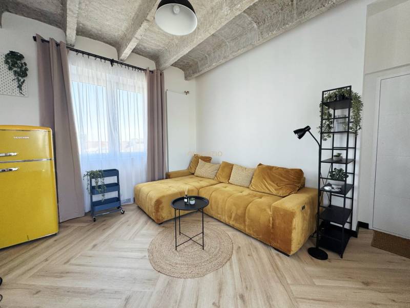 - PRENÁJOM - 3 IZBOVÝ BYT - WILSONOVA UL. - STARÉ MESTO - Obývacia izba s podlahou s dreveným dekorom, žltou sedačkou a retro chladničkou.