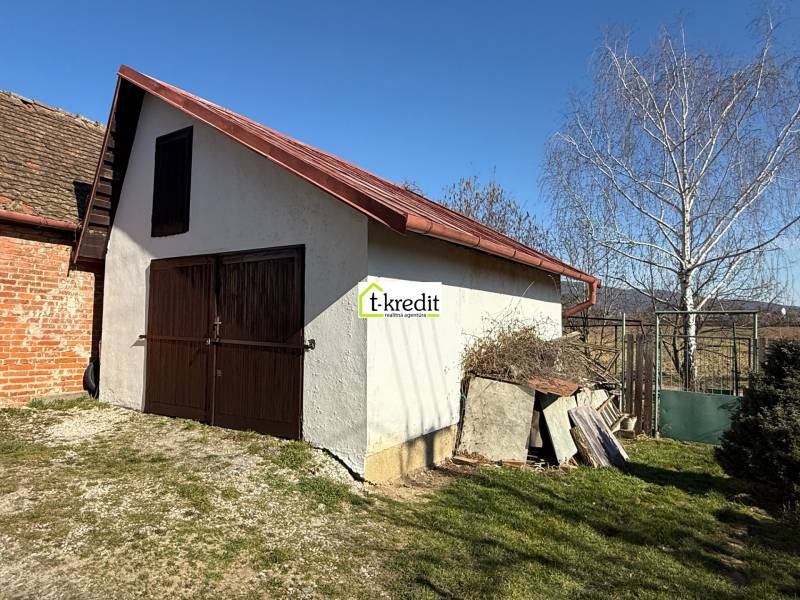 PREDAJ - CHATA S VINICOU - ZLATÉ MORAVCE - Chata v Zlatých Moravciach s drevenými dverami a šikmou strechou na dvore.