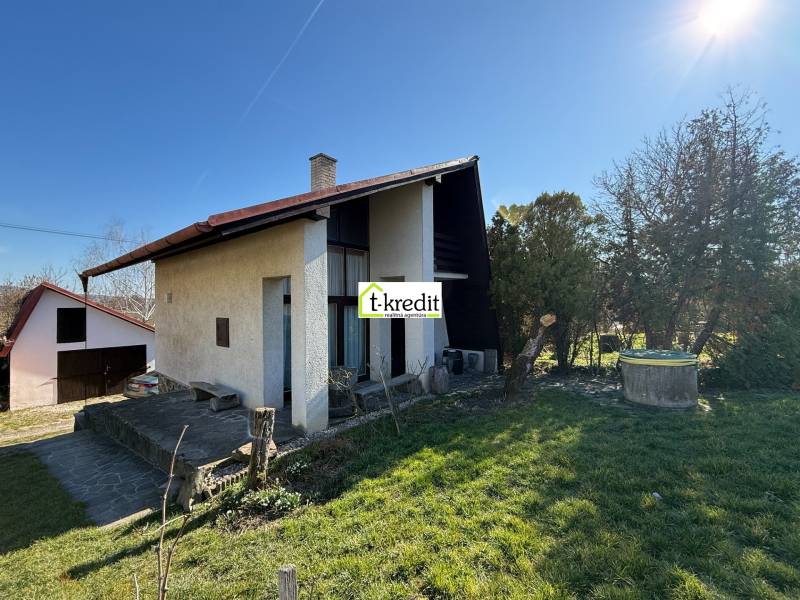 PREDAJ - CHATA S VINICOU - ZLATÉ MORAVCE - Chata v Zlatých Moravciach obklopená záhradou a trávnikom pod jasnou oblohou.