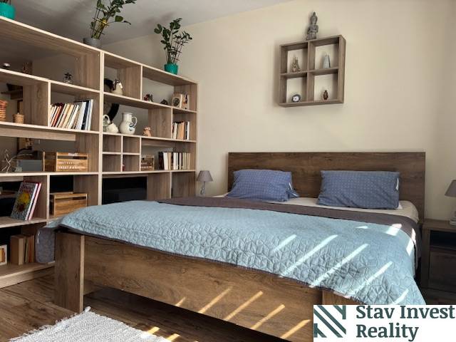 Exkluzívny investičný apartmán/byt  na predaj v srdci Donovál  - Spálňa v 1-izbovom byte s dreveným nábytkom, posteľou a policovým systémom.