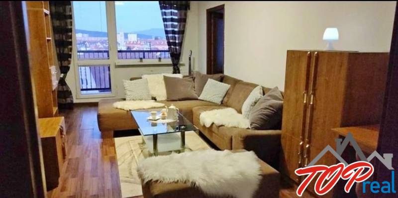 PRENÁJOM - Pekný 3 - izbový byt - Košice - Juh  - Obývacia izba v 3-izbovom byte s pohovkou, skleneným stolom a výhľadom z okna.