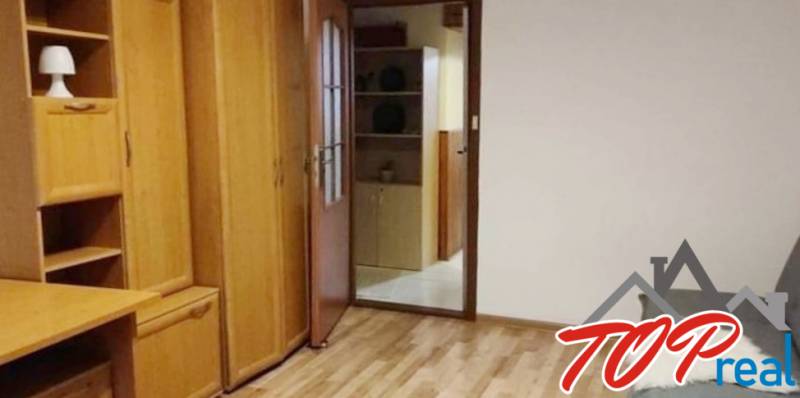 PRENÁJOM - Pekný 3 - izbový byt - Košice - Juh  - Drevený nábytok v izbe 3-izbového bytu s parketovou podlahou a otvorenými poličkami.