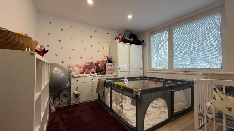 KOMPLETNE prerobený 4i byt s balkónom, 77m2 - ZÁTVOR - Detská izba v 4-izbovom byte s hernou ohrádkou a bielym nábytkom.