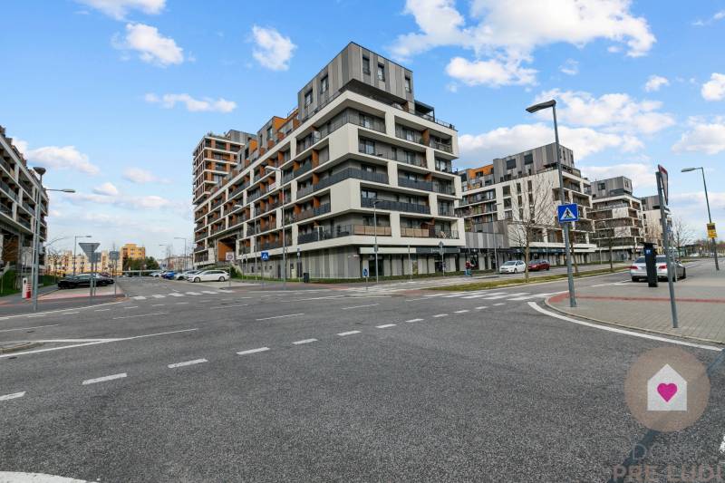 BA/PETRŽALKA-Prenájom 1i bytu s klimatizáciou a balkónom - Slnečnice - Križovatka s modernými budovami v Bratislave - Petržalke, obloha s oblakmi.