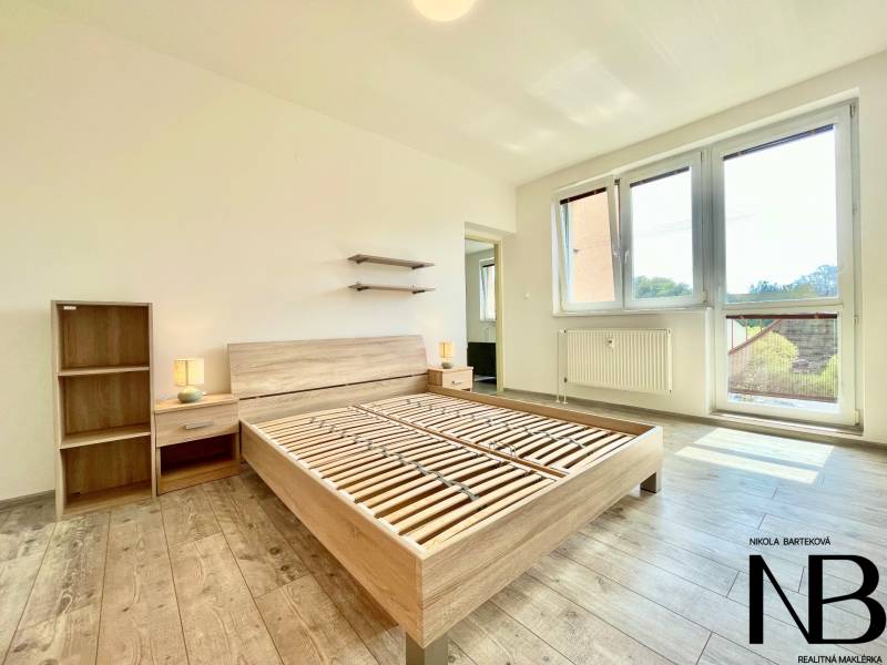 Na prenájom slnečný 2i byt s balkónom, ul. Východná, Trenčín - Svetlá izba s drevenou podlahou, posteľou a nábytkom, 2-izbový byt na ulici Východná.