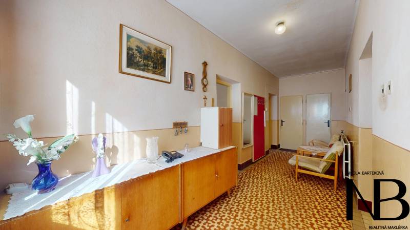 Rodinný dom s veľkým pozemkom a garážou, Dvorec - Chodba v rodinnom dome so starším nábytkom a retro doplnkami.