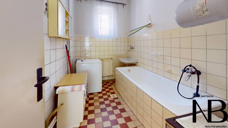 Rodinný dom s veľkým pozemkom a garážou, Dvorec - Kúpeľňa s vaňou, umývadlom, práčkou v rodinnom dome. Dlažba červeno-krémová.