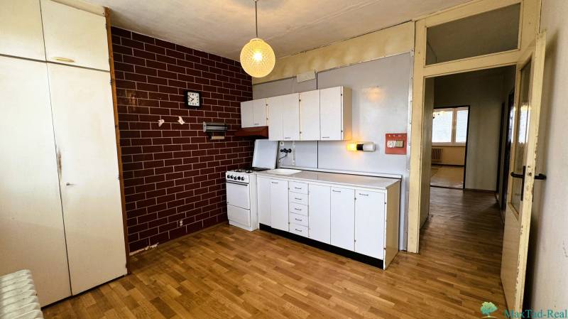 REZERVOVANÉ  3-izbový byt | Škultétyho ulica,  77,4 m², Trebišov. , - Kuchyňa v 3-izbovom byte s bielymi skrinkami a podlahou s dreveným dekorom.
