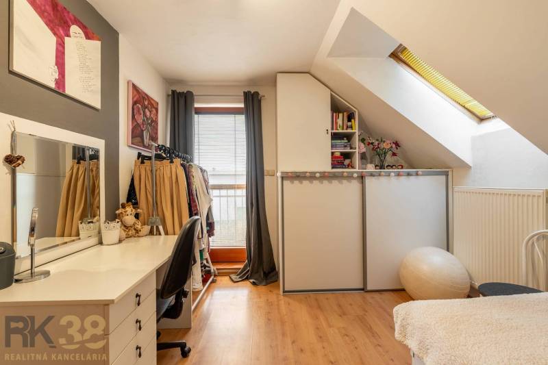 Predaj priestranného rodinného domu v historickej časti Popradu  - Interiér rodinného domu s podlahou s dreveným dekorom, pracovný stôl a úložné priestory.